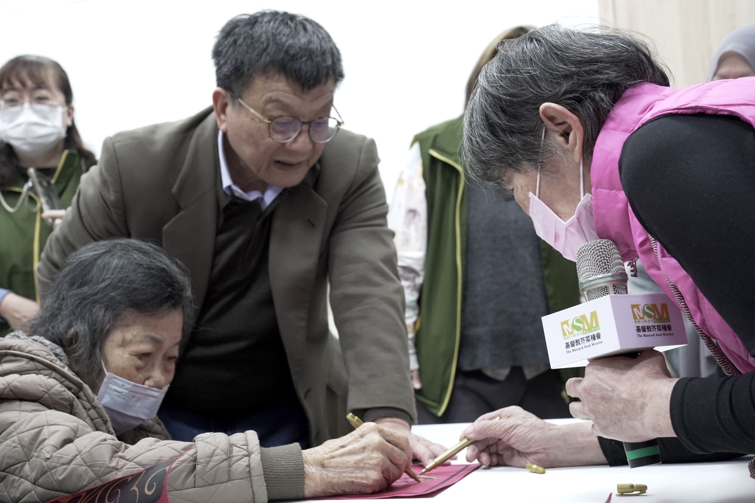 芥菜種會「共學師」(右一)引導五股助人網「樂福學堂」長者描繪年畫迎新春。（芥菜種會提供）